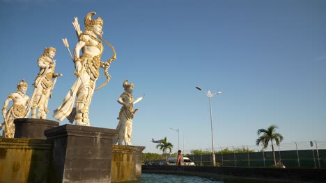 sunny day bali island airport district street fountain monument aircraft landing slow motion panorama 4k indonesia