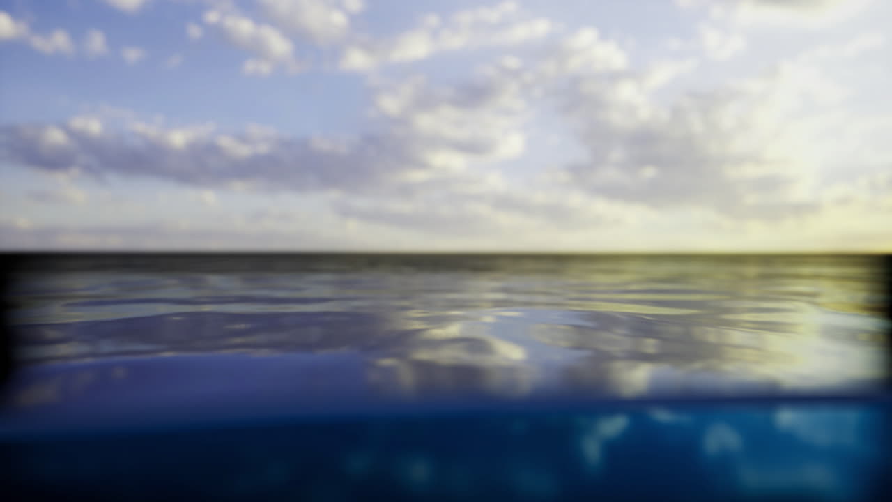 The sun sets over a tranquil ocean casting a warm glow on the water