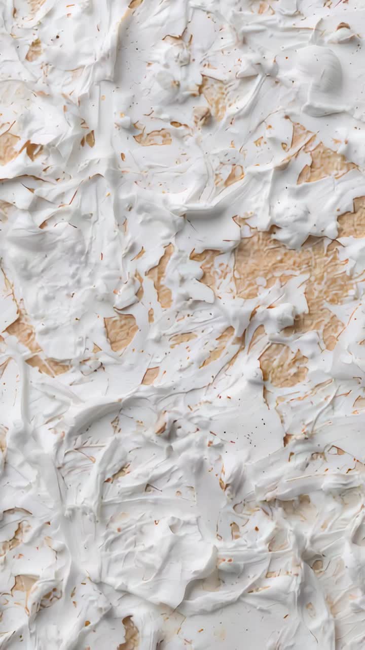 Vertical video: Panning camera showing thick white spread on table to reveal tan base and flecks