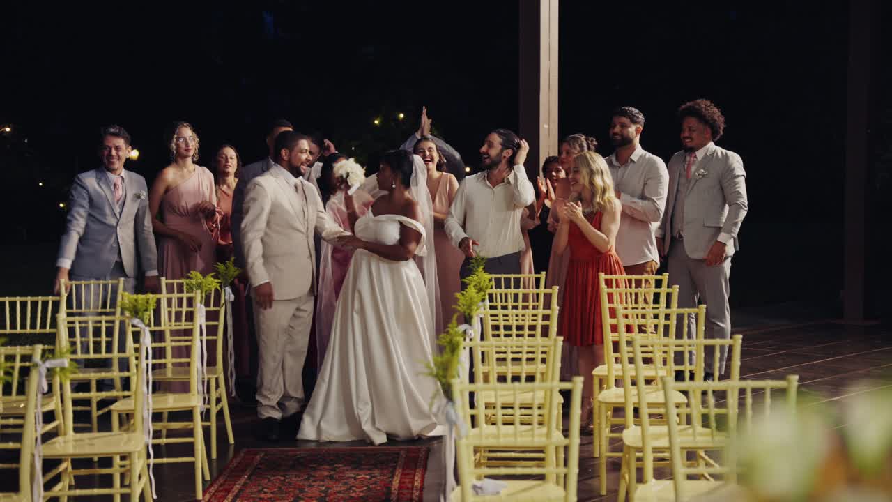 A joyful wedding ceremony with the bride and groom kissing and guests cheering