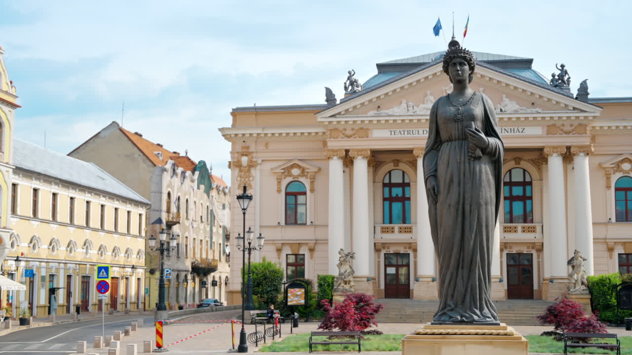 ORADEA, ROMANIA - MAY 22, 2023: View of the Statue of Queen Marie of Romania. State Theatre and square on the background in Oradea downtown