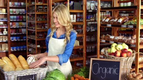 smiling staff holding bread in organic section