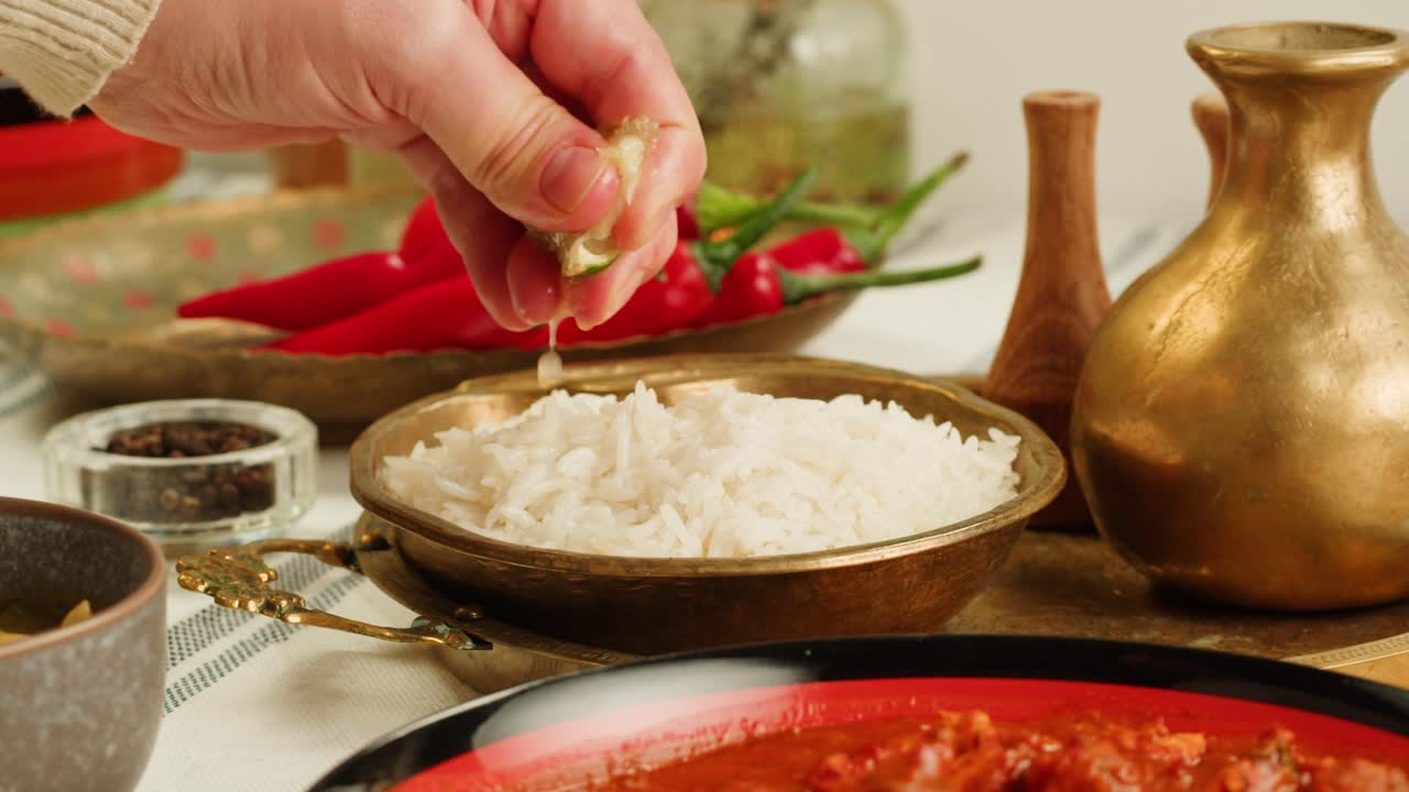 Assorted indian sri-lanka food set on wooden background. Dishes and appetisers of indeed cuisine, rice, lentils, paneer, samosa, spices, masala. Bowls and plates with indian food top view chicken. High quality 4k footage
