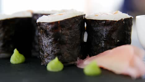 Maki-Sushi-served-on-grey-stone-slate-with-soy-sauce