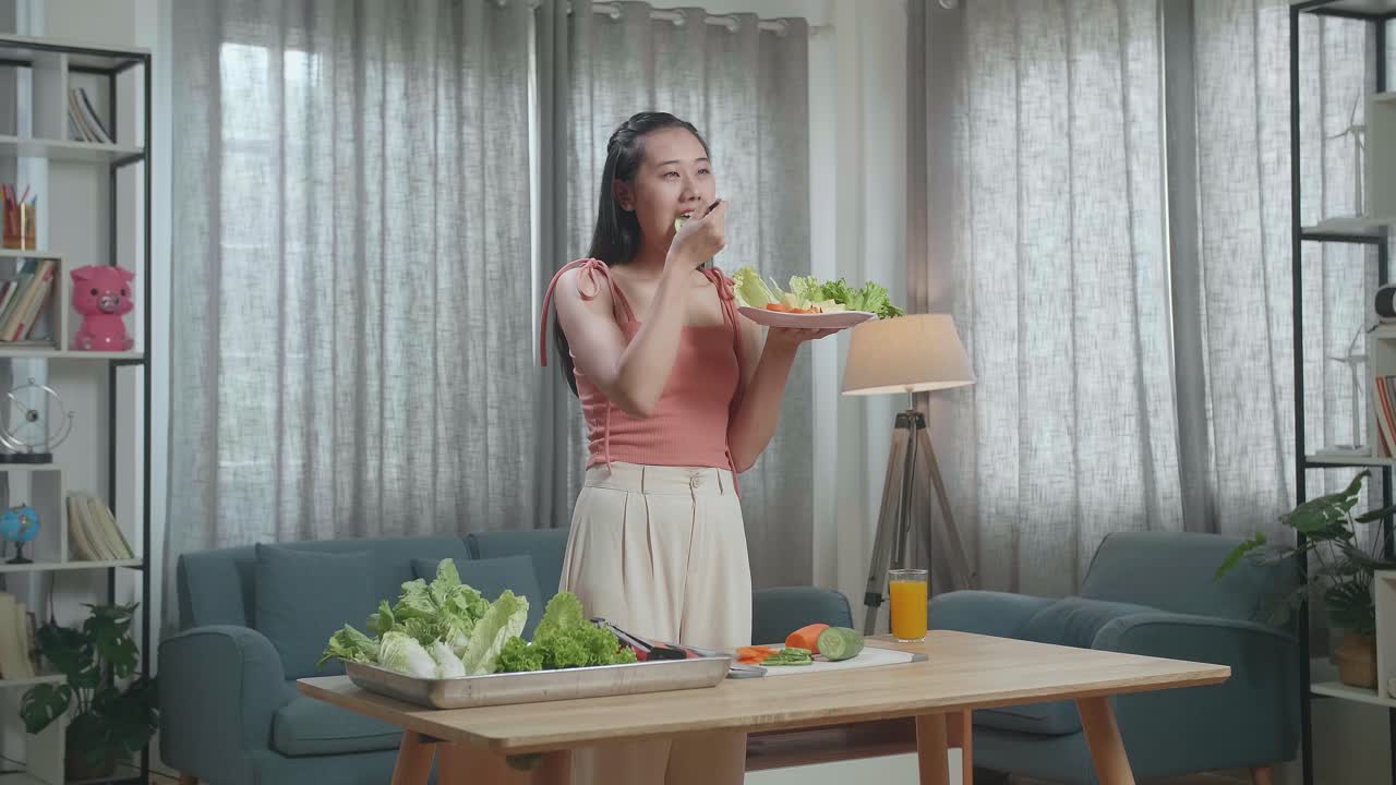 웃는 아시아 여성은 집에서 건강한 음식을 먹는 것을 즐긴다.