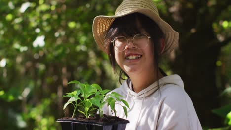 portrait of asian girl gardening and smiling on sunny day