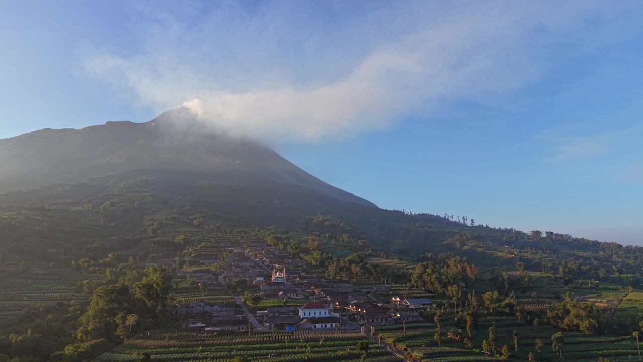 Vista aerea di un villaggio circondato da campi fertili vicino al Monte Merapi. La bellezza naturale e il fascino rurale definiscono il paesaggio