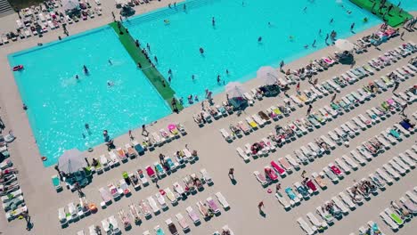 Aerial-Flying-over-the-beach-lot-of-people-are-sunbathing-swimming-in-the-pool