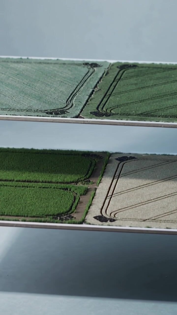 Vertical video: Reframing handheld camera moving stacked prints on shelf, revealing tractor tracks