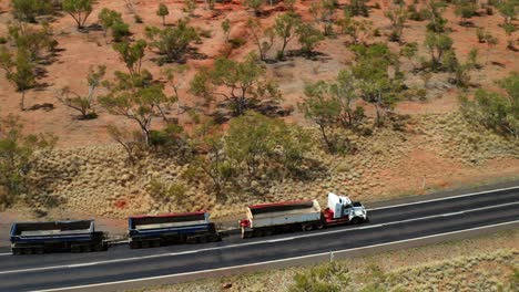 tren de carretera de tres remolques con carga vacía conduciendo en outback road en qld, australia