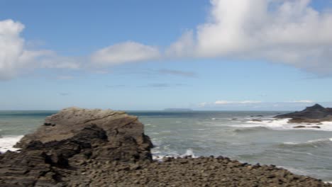 wide-shot-of-Eye-cove-with-the-sea-rolling-up-the-beach,-Taken-at-Hartland-Quay,-Stoke,-Hartland,-Bideford