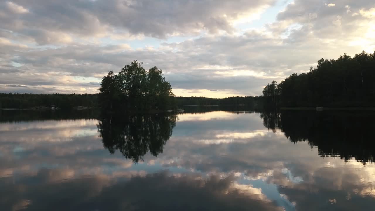An aerial footage of a calm lake during sunset in lakeland finland.