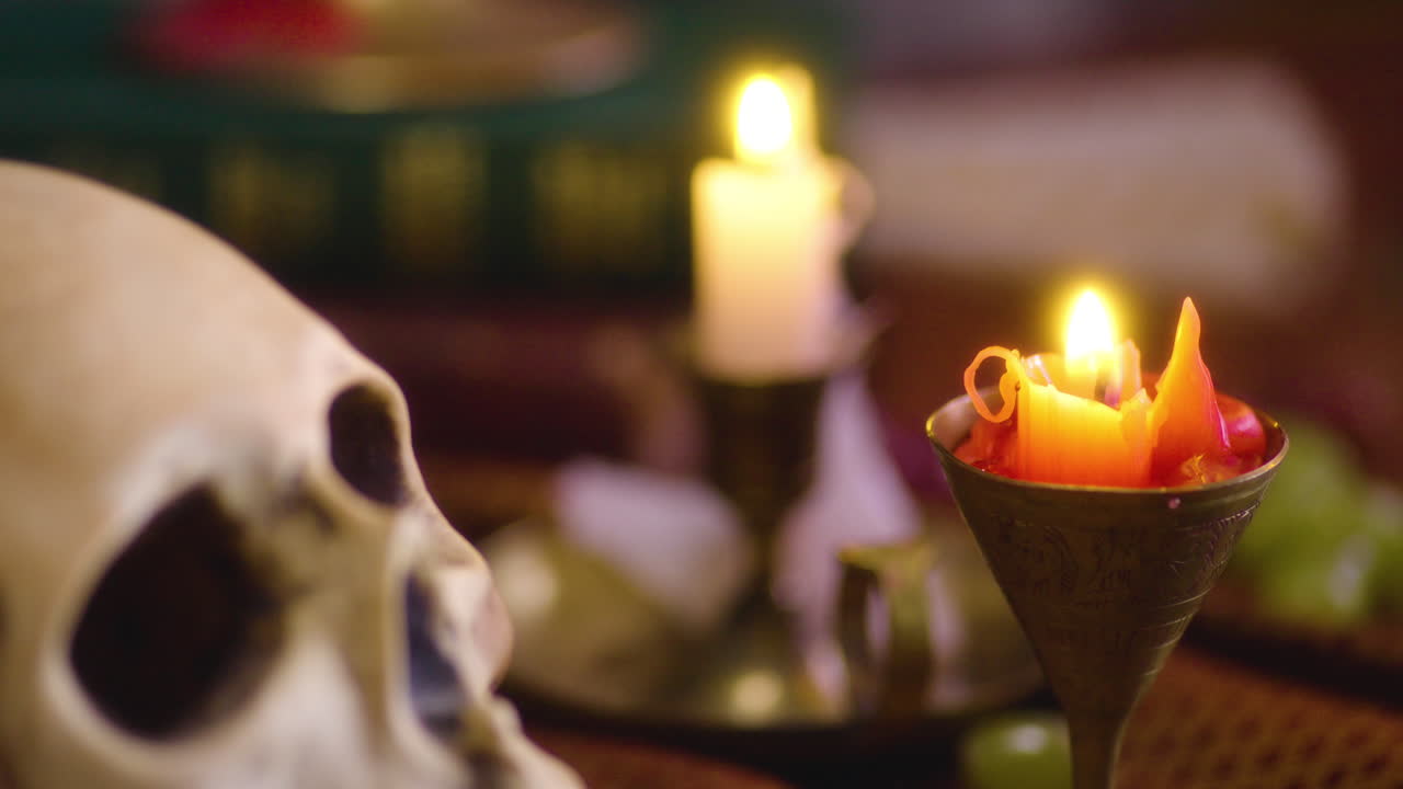 oscuro y místico: primer plano de velas, cráneos y libros antiguos - estética gótica