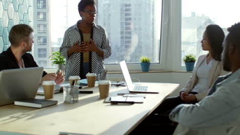 Businesswoman-Is-Standing-Explaining-A-Project-To-Her-Colleagues-In-The-Office