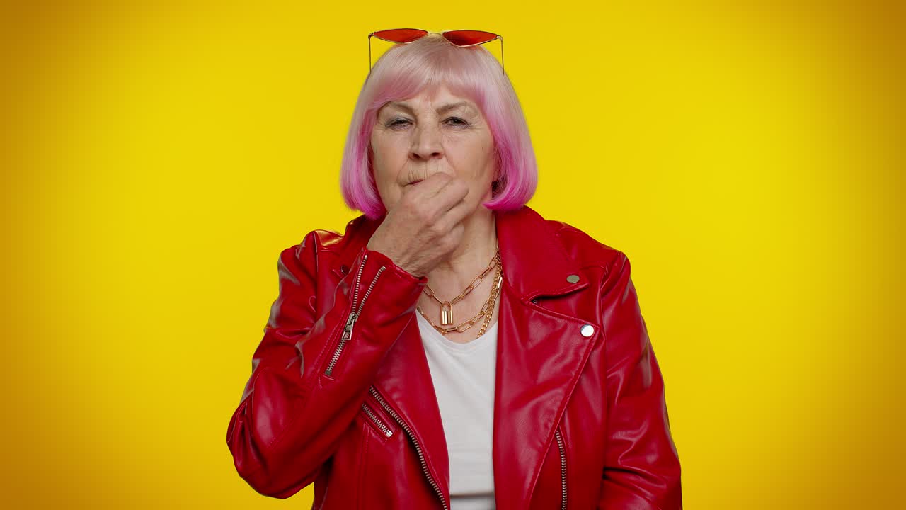 Elderly granny woman presses index finger to lips makes silence gesture sign do not tells secret