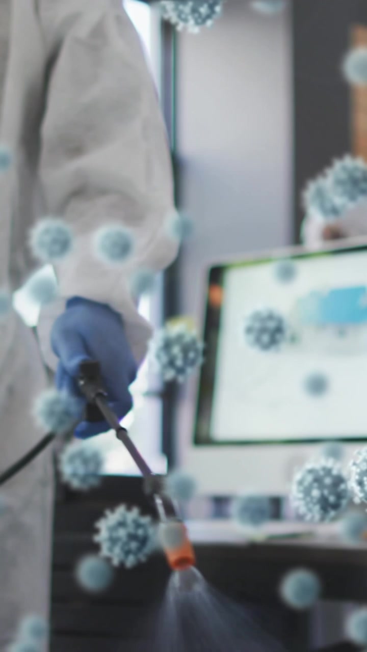 Multiple covid-19 cells floating against male health worker spraying disinfectant at office