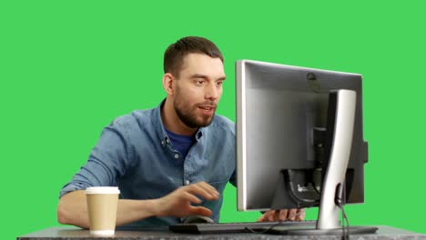 un hombre elegante navegando por internet sentado en su escritorio. filmado en un fondo de pantalla verde.