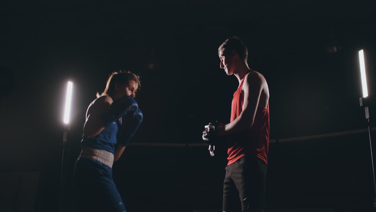 kickboxer mujer atleta entrenadora de kickboxing entrenando amigas de acondicionamiento físico boxeando golpeando guantes de enfoque disfrutando de un entrenamiento intenso juntos en el gimnasio de cerca