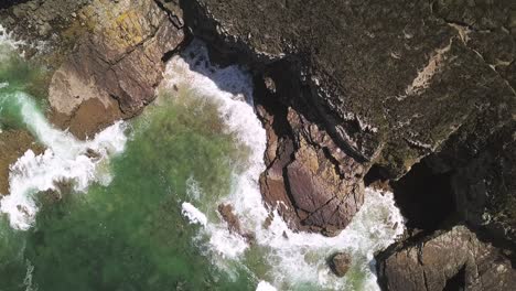 aerial drone view of waves clipping on cliffs