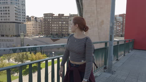 woman on a bridge in a city