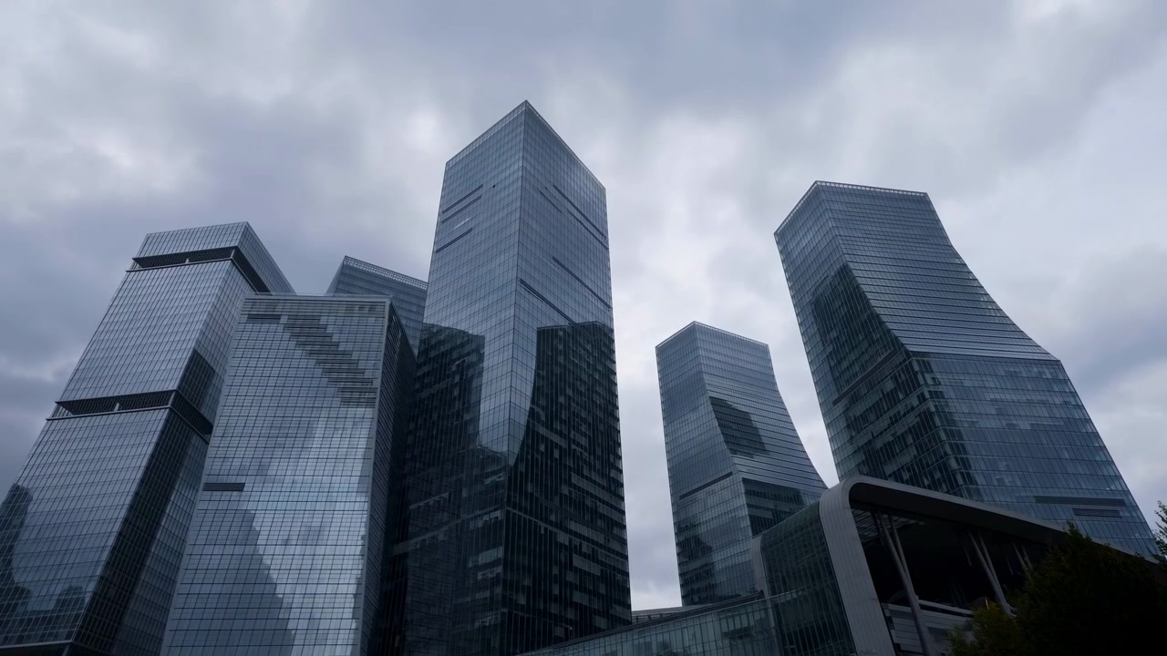 Arranha-céus de vidro sob nuvens de tempestade, fachadas refletivas dominam o distrito corporativo com ângulo baixo.