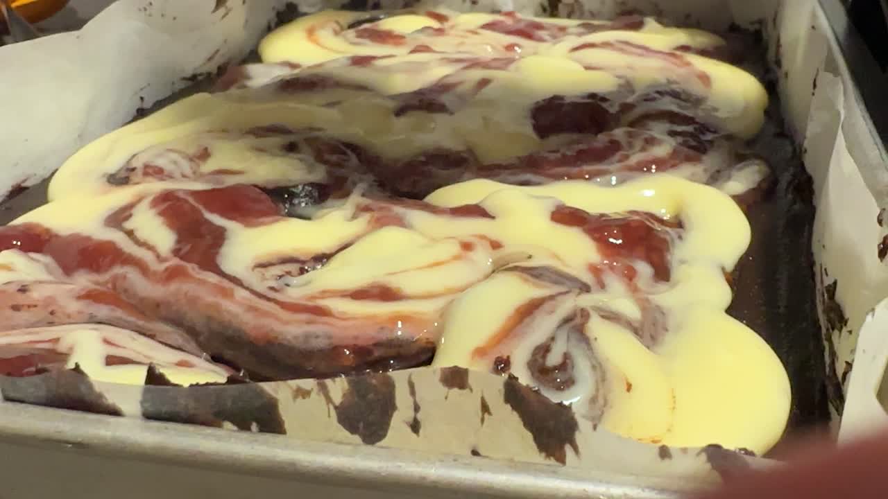 Icing swirling cinnamon bake dolloping with spoon, baking Australia