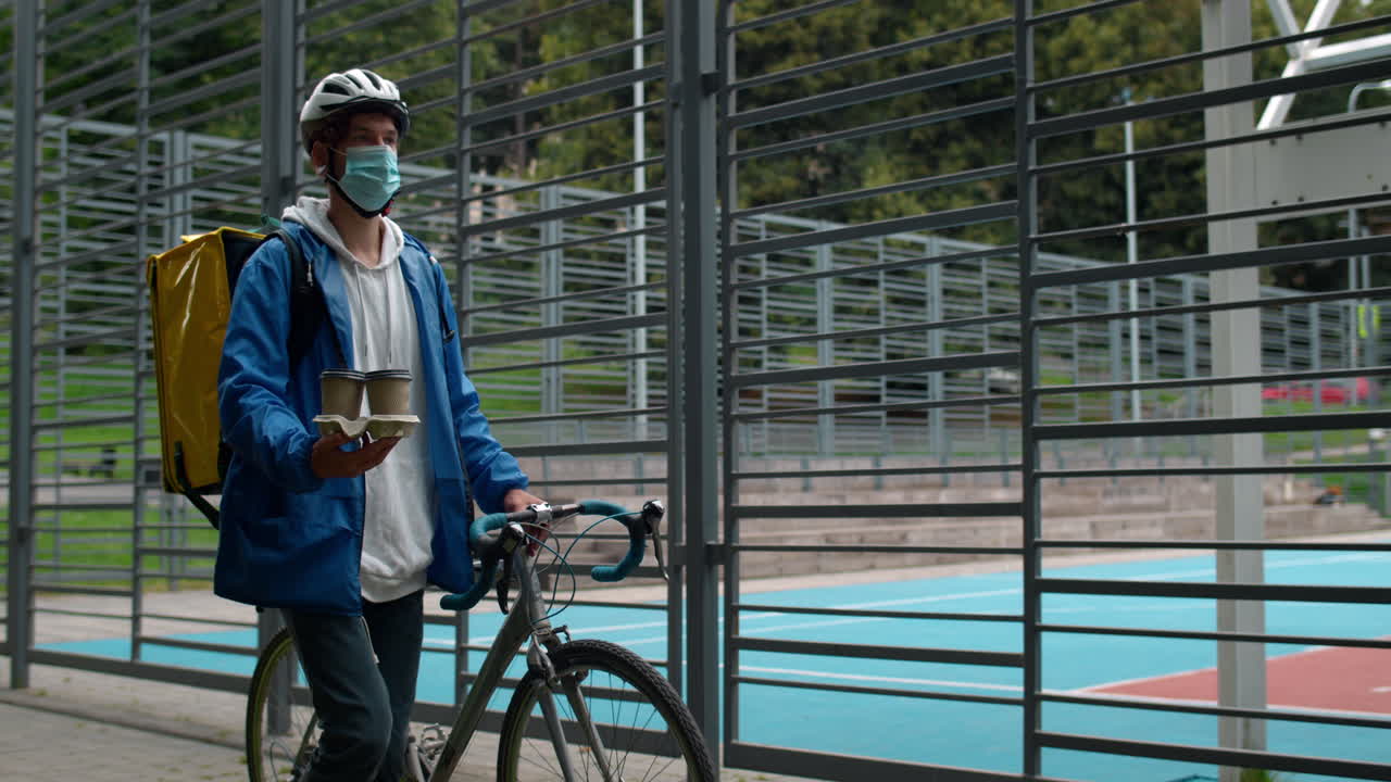 A delivery person with a bicycle and backpack