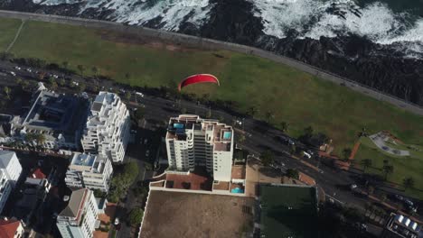 paraglider flying over city of cape town, south africa