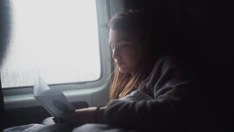 woman reading book in car