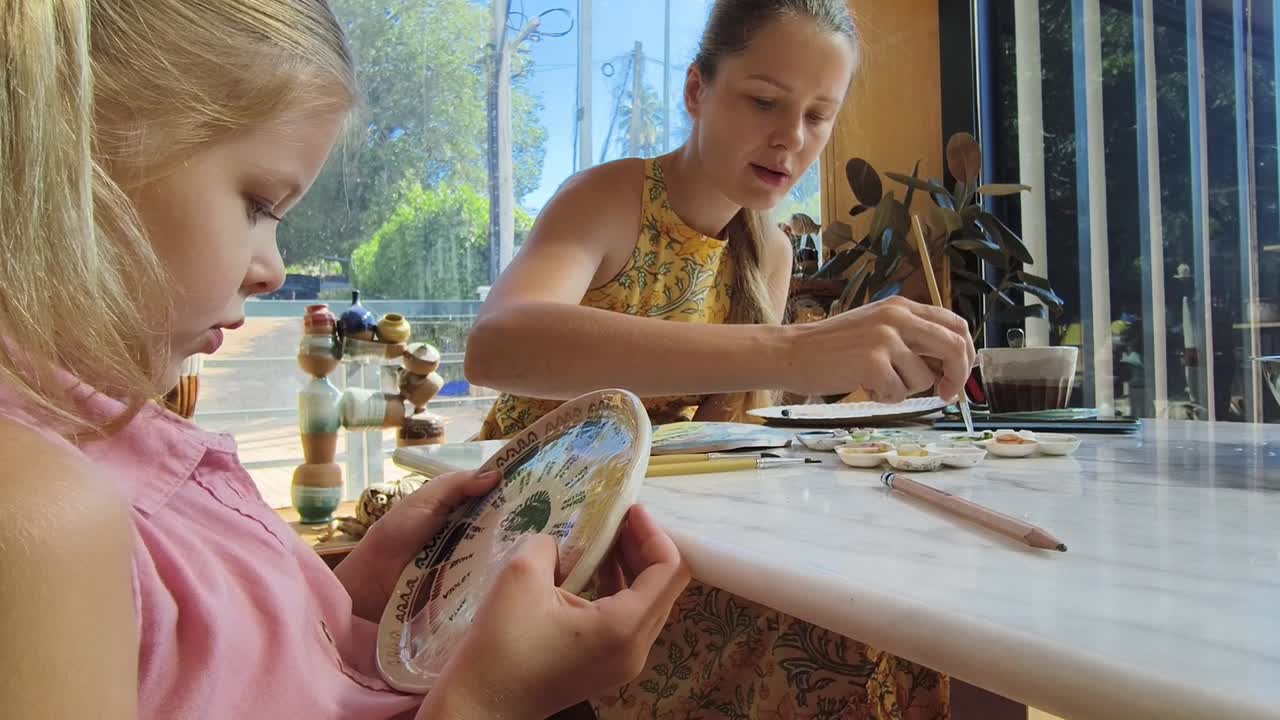 madre e hija pintando platos