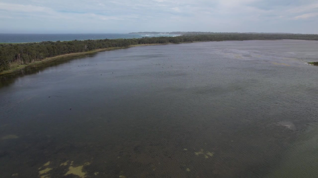 Vista aérea do pitoresco Lago Budgewoi na costa do Mar da Tasmânia. Costa Central de NSW, Austrália. Imagem lateral de drone.