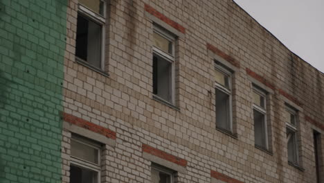 abandoned brick building with broken windows and fire escape