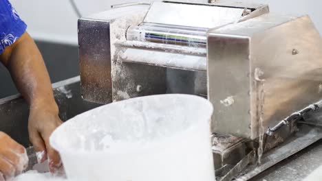 worker slicing and shaping dough by hand