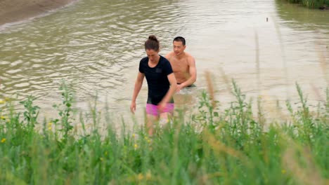 front view of fit  caucasian people jogging in water at countryside 4k