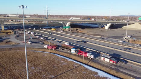 aerial view of fallen cargo container recovery operation after rollover near exit ramp from the champlain bridge in brossard, montreal, canada