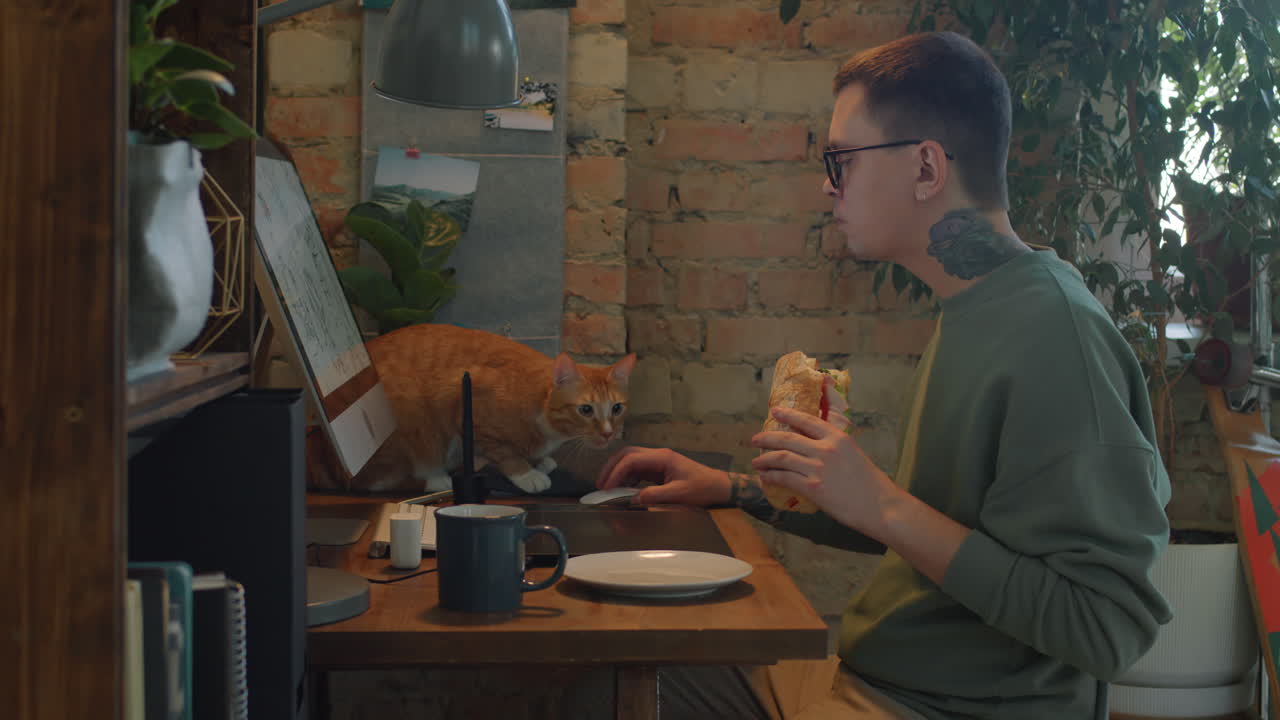 Graphic designer che mangia un panino sul posto di lavoro