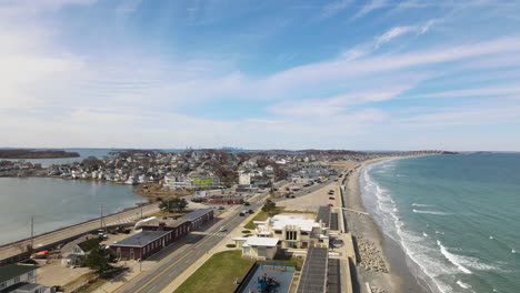 static drone shot of seaside town with boston city in the distance