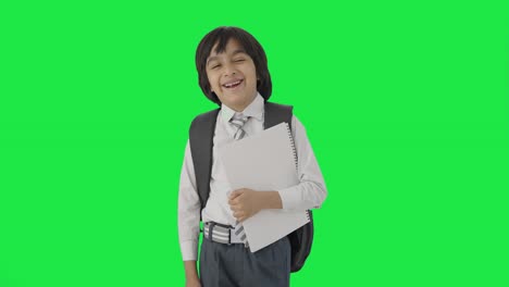 niño de escuela indio feliz de pie con libros pantalla verde