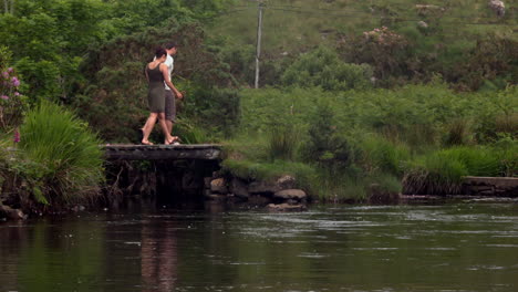 Couple-walking-past-a-peaceful-lake-in-the-countryside