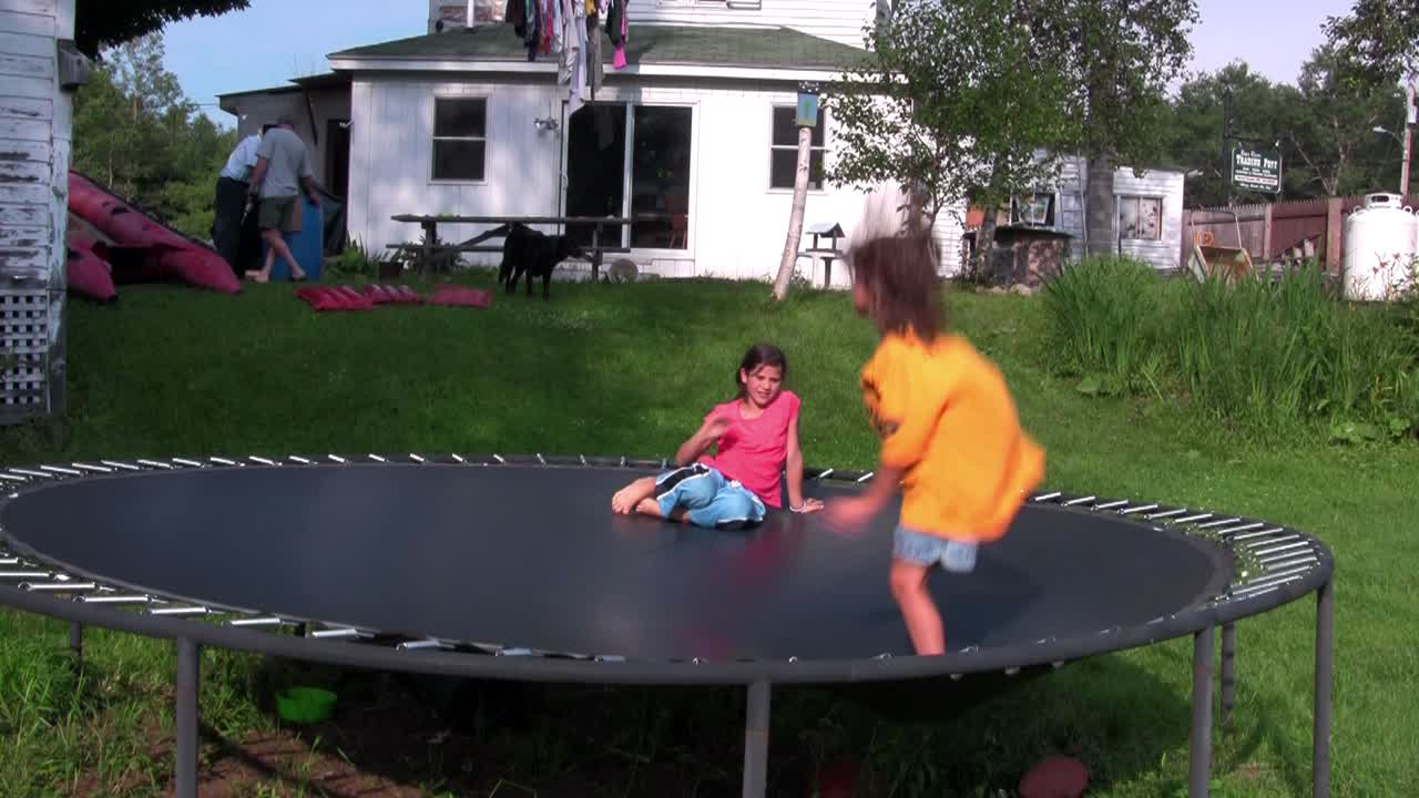 뒷마당 1의 트램폴린에서 아이들이 뛰어 놀고 있습니다.