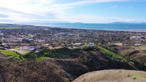 2020 - aerial over the pacific coastal green hills and mountains behind ventura california including suburban homes and neighborhoods 1