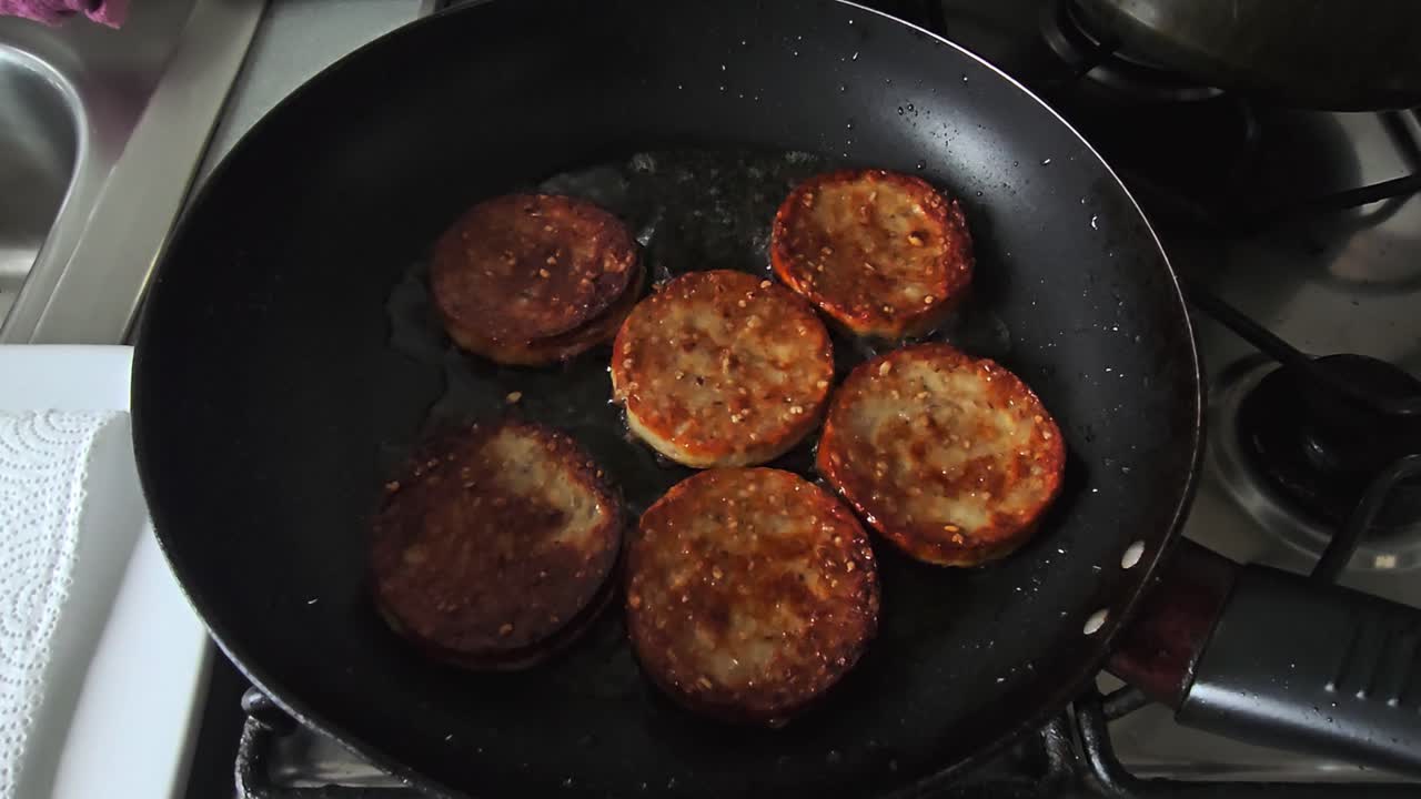 Handheld video of white pudding cooked in a pan with oil wide shoot