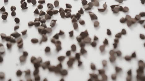 Video-of-close-up-of-multiple-chocolate-chip-over-white-background