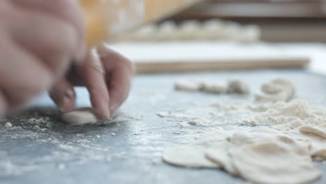 making meat dumpling with wooden rolling pin.