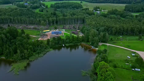 Waldeinschlag-Um-Neu-Gebautes-Haus,-Umgeben-Von-Grünen-Bäumen-Und-Einem-See-In-Lettland