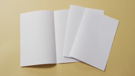 video of white sheets of paper with copy space on yellow background