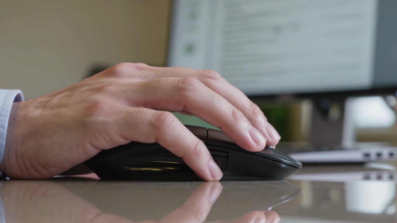 Clicking right hand in light blue cuff using mouse at office desk, moving to blue chart