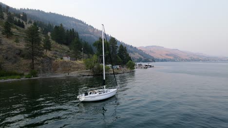 toma aérea de 4k sobre el lago okanagan volando hacia atrás y pasando veleros muy de cerca en vernon, columbia británica