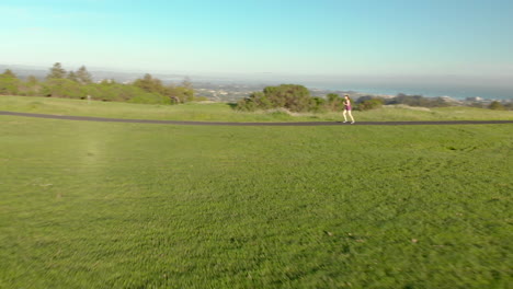 Aerial-of-Young-Woman-Running-on-a-Track-at-Sunset