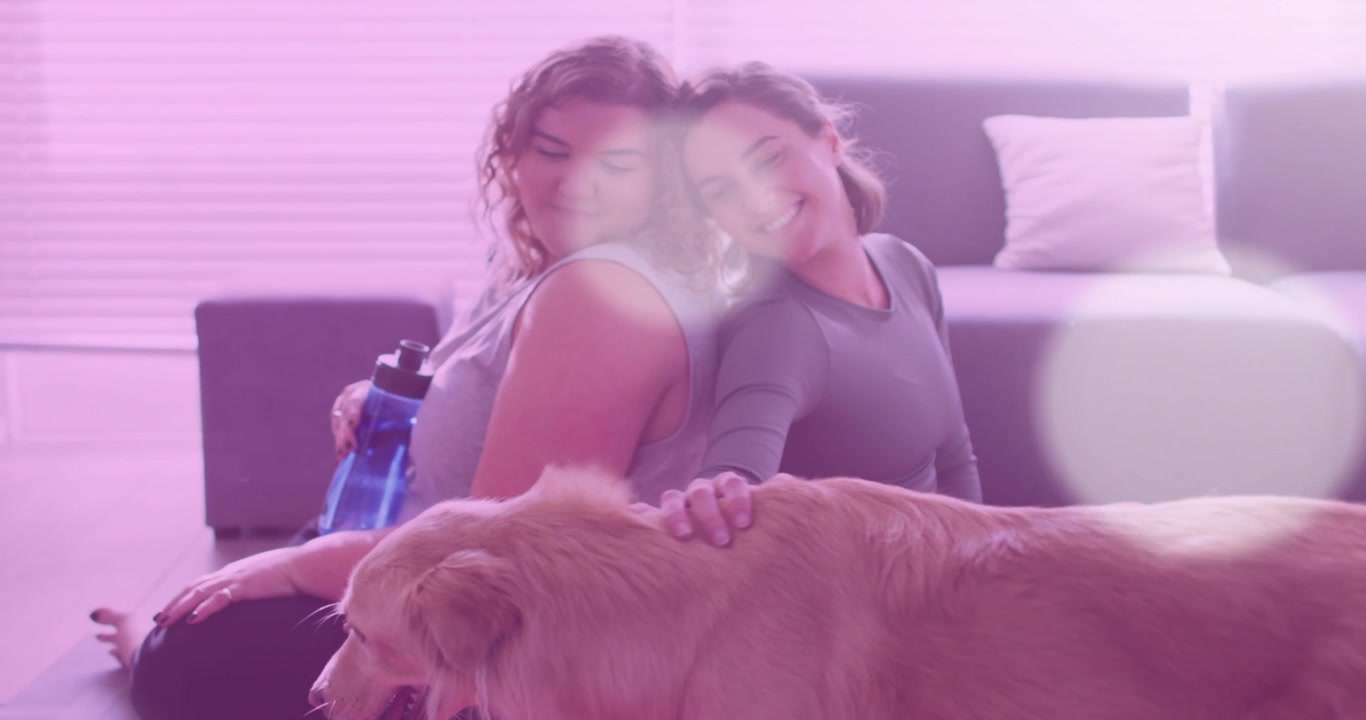 Due donne che si rilassano a casa con il loro Golden Retriever